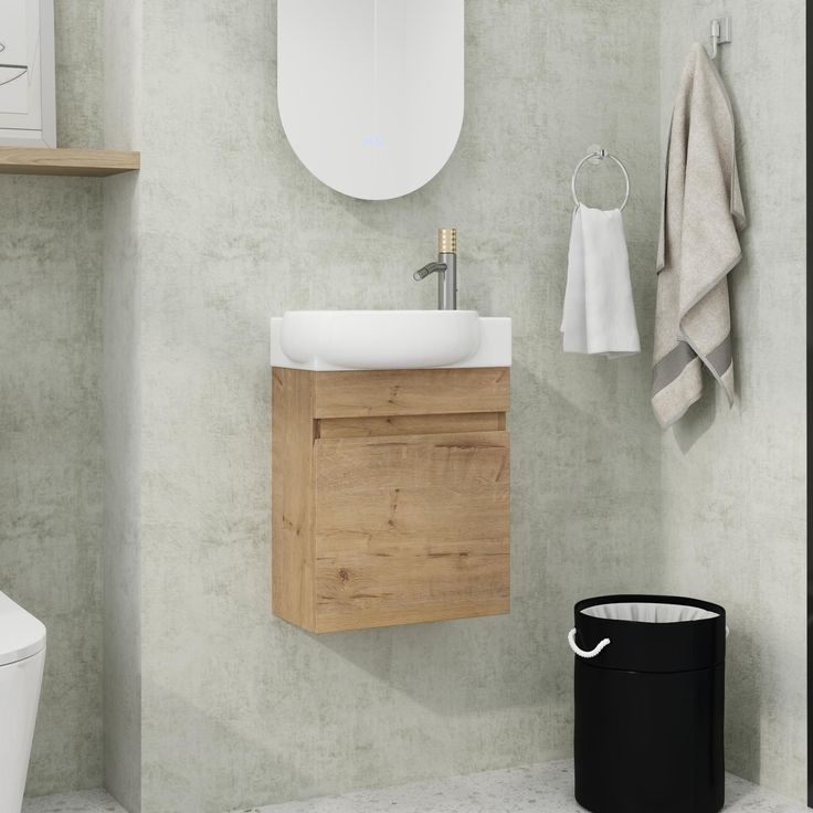 a white toilet sitting next to a bathroom sink under a mirror above a wooden cabinet