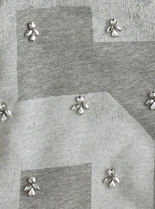 several small silver bees on a gray and white checkered fabric