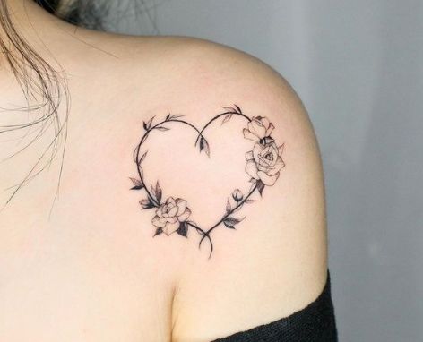 a woman with a heart shaped tattoo on her shoulder