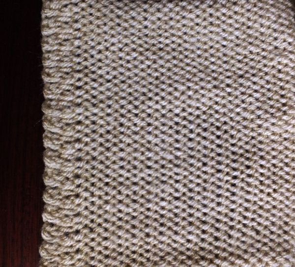 a knitted piece of cloth on top of a wooden table