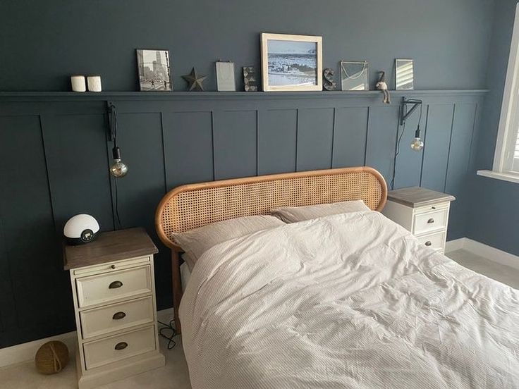 a bedroom with blue walls and white bedding