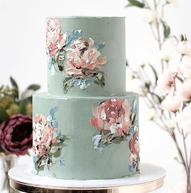 a three tiered cake with flowers painted on it