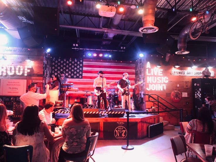 a group of people that are sitting in front of a microphone and some guitars on stage