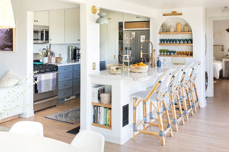 a kitchen with white counter tops and wooden stools