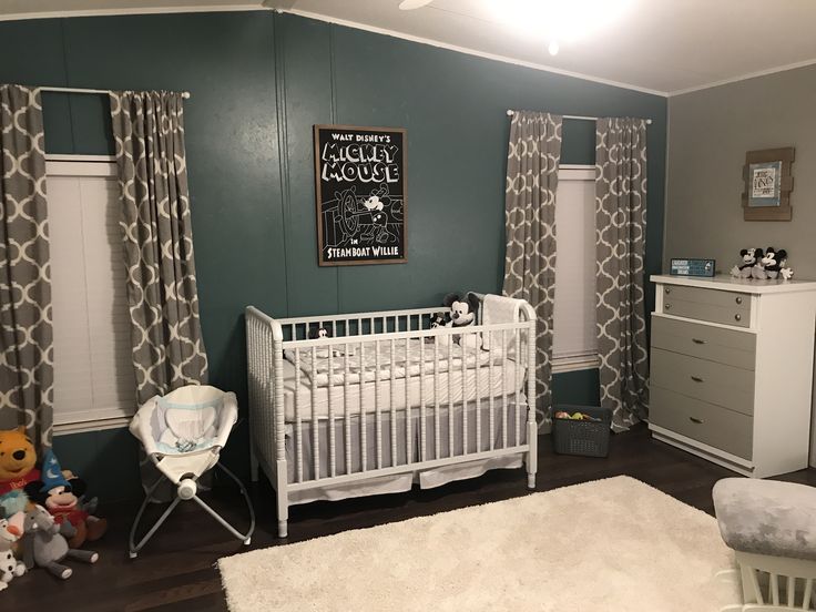 a baby's room with green walls and white furniture, including a crib