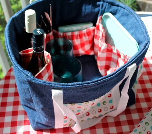 a blue and white checkered picnic basket with bottles in it