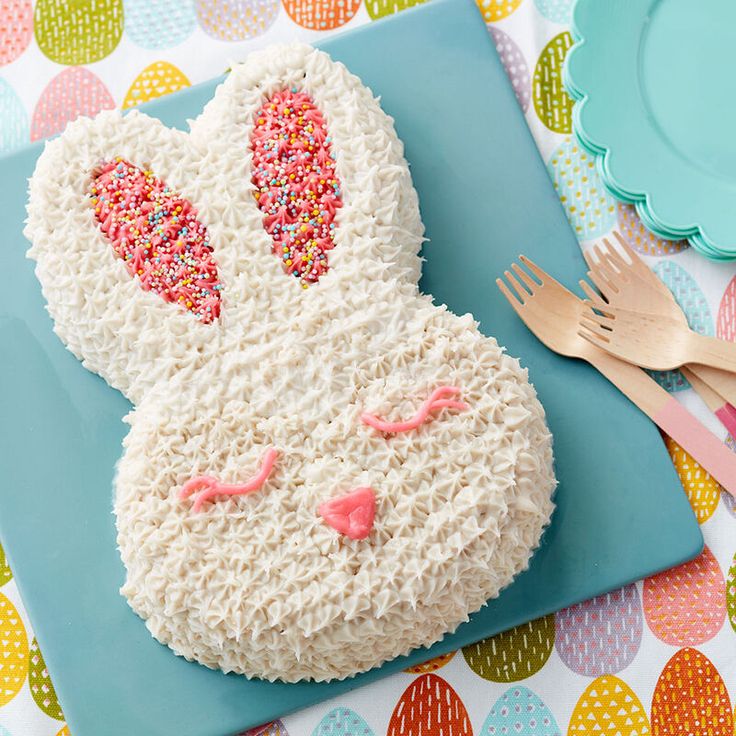 a cake decorated with white frosting and pink sprinkles on a blue plate