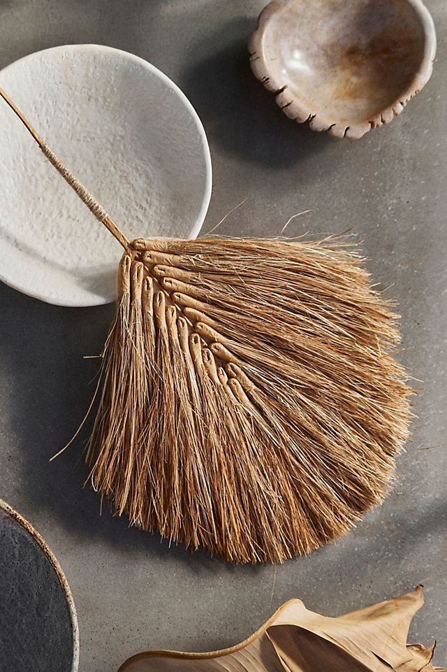 three bowls and two spoons on a table with dried grass in them next to some other items