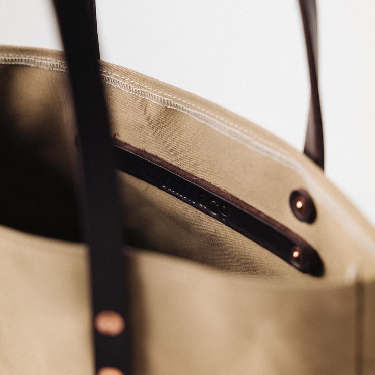 The Field Tan Canvas tote is a canvas and leather tote handmade in the KMM & Co. studio in Atlanta. Each one is meticulously crafted from heavyweight canvas and gorgeous full-grain leather. Field Tan Canvas is a type of cotton canvas known as duck cloth. It's one of the most durable types of cloth, and it's structured enough to stand up on its own. The Field Tan Canvas tote comes standard with Dark Brown handles. Everyday Use Canvas Shoulder Bag With Leather Lining, Everyday Canvas Shoulder Bag With Leather Lining, Canvas Tote Bag With Leather Lining, Waxed Canvas Bag With Leather Handles For On-the-go, Everyday Waxed Canvas Bag With Leather Lining, Everyday Waxed Canvas Bags With Leather Lining, Canvas Satchel Bag With Leather Lining, Everyday Duck Canvas Bag With Waxed Finish, Leather Canvas Bag With Canvas Lining For On-the-go