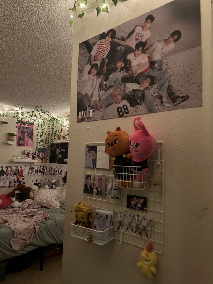 a bedroom with posters and stuffed animals on the wall