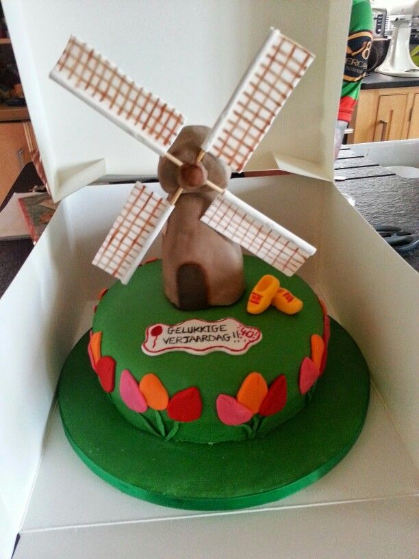 there is a cake in the shape of a windmill on top of a green box