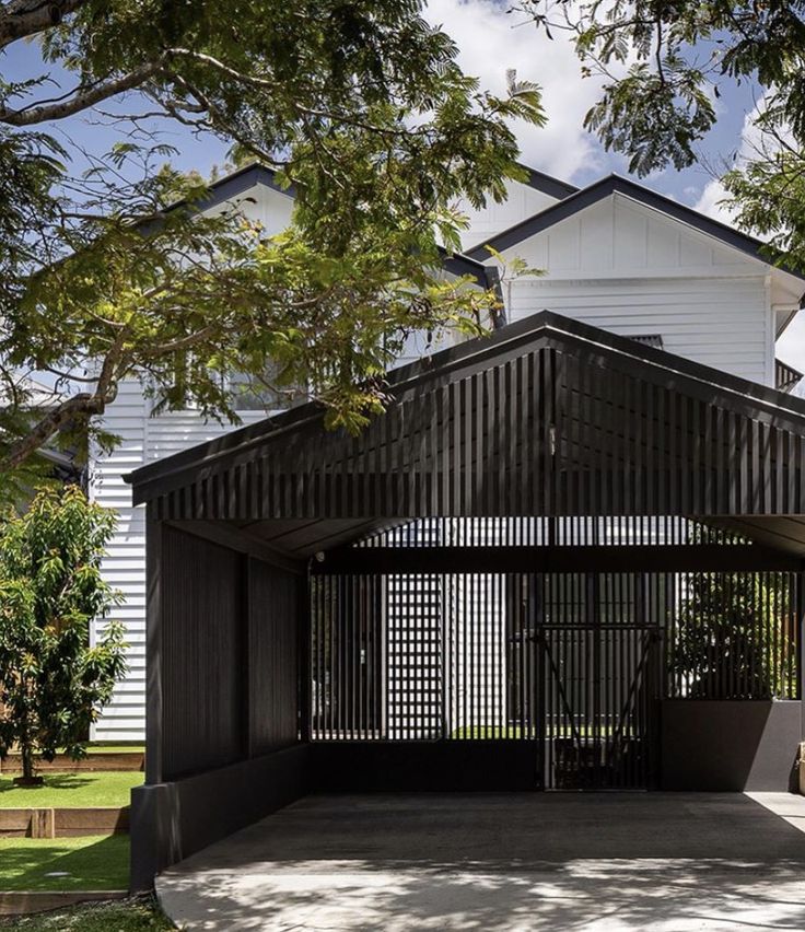 a white house with a black fence and trees