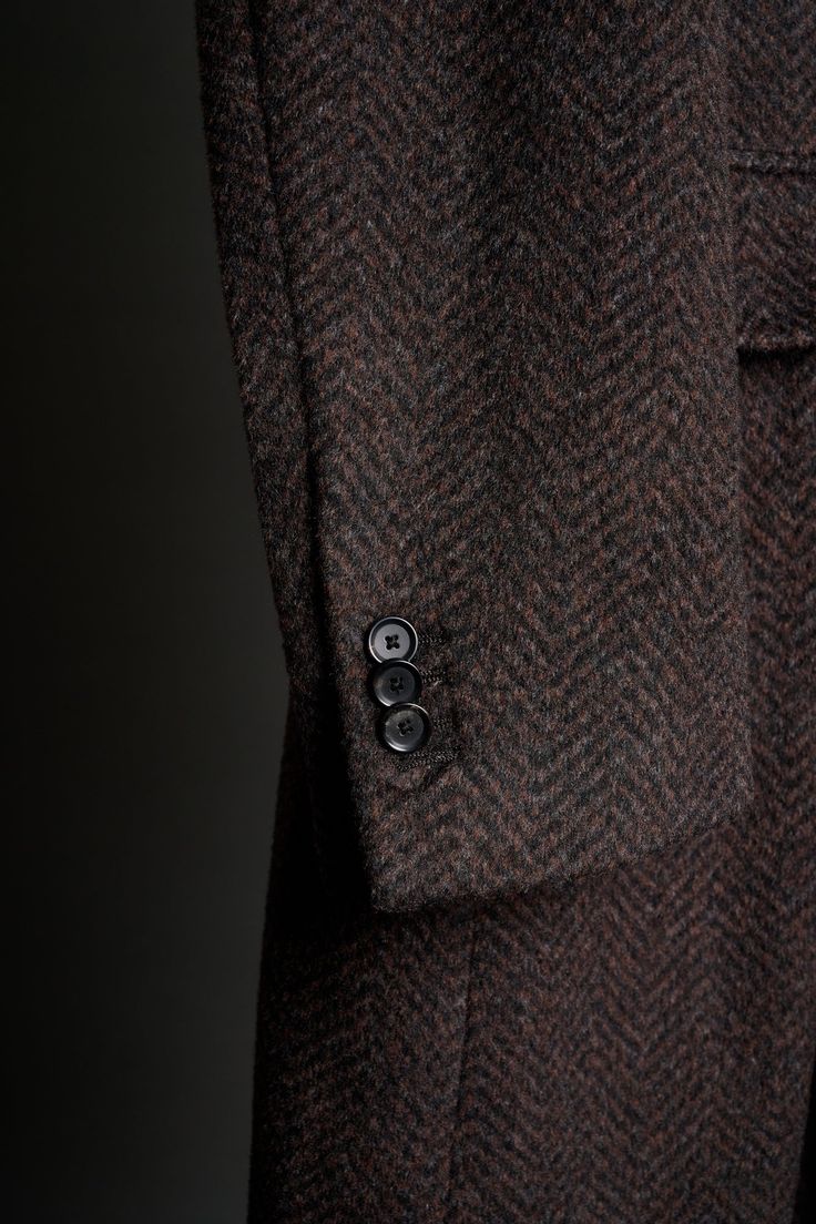 A handmade bespoke overcoat crafted from a classic herringbone fabric with a perfect balance of warmth, durability, and softness. The substantial weight provides exceptional insulation, making it ideal for colder weather. The classic herringbone pattern adds a touch of sophistication and the texture is unmatched. Formal Wool Outerwear With Herringbone Pattern, Formal Herringbone Outerwear With Lapel Collar, Business Wool Coat With Herringbone Pattern, Luxury Long-sleeve Herringbone Outerwear, Brown Wool Outerwear With Herringbone Pattern, Brown Wool Herringbone Outerwear, Timeless Herringbone Outerwear For Formal Occasions, Timeless Formal Outerwear With Herringbone Pattern, Timeless Herringbone Pattern Formal Outerwear