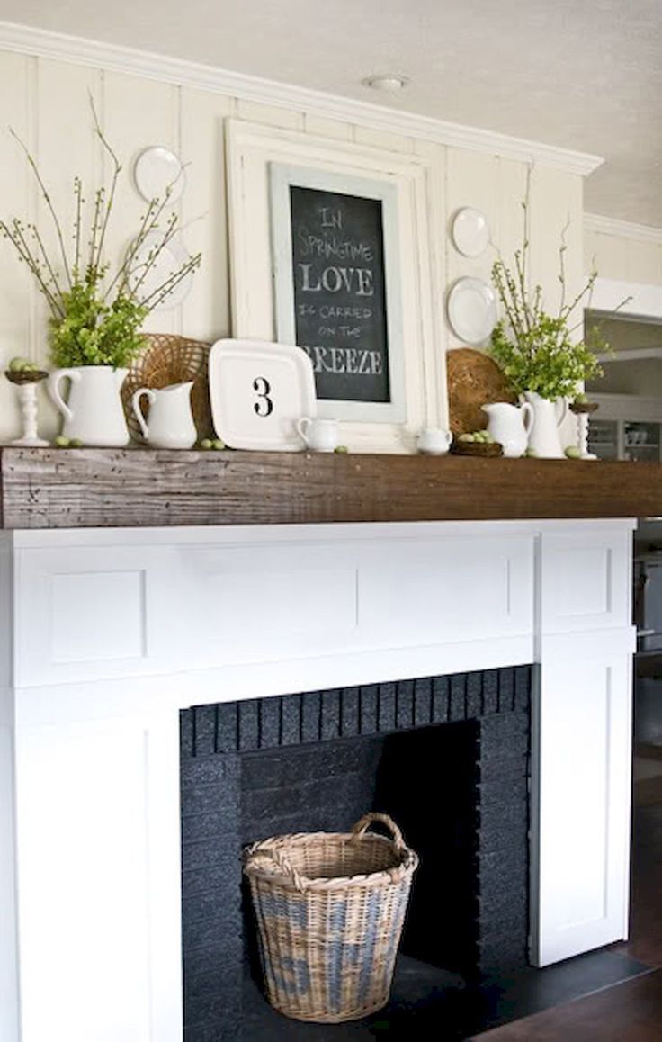 the fireplace is decorated in white and has potted plants on top