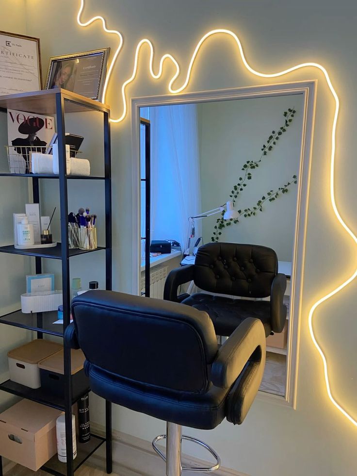 a chair sitting in front of a mirror with lights on the wall and shelves below it