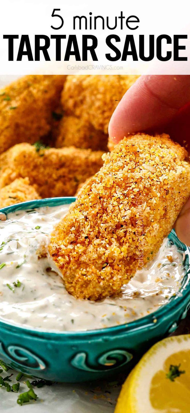 a hand dipping some food into a bowl with sour cream and garnished with parmesan cheese