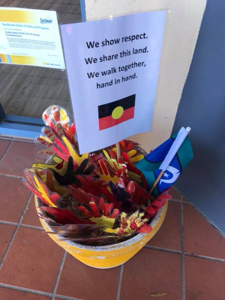 a yellow bucket filled with lots of different colored items next to a sign that says we show respect