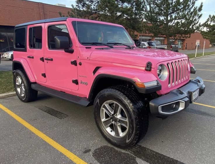 a pink jeep parked in a parking lot