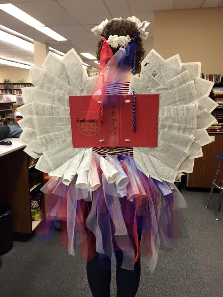 a woman wearing a costume made out of books and paper with ribbons around her neck