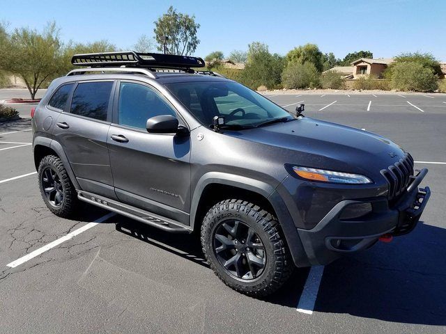 a gray jeep parked in a parking lot