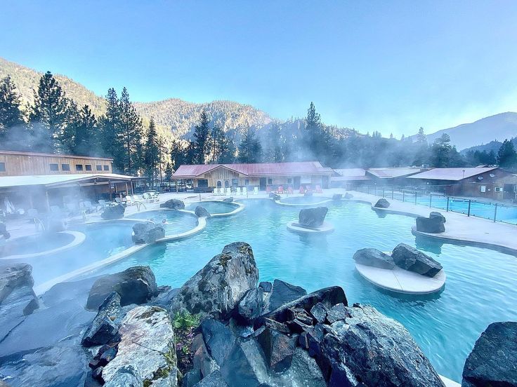 an outdoor swimming pool with hot springs surrounded by mountains