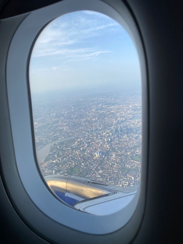 an airplane window looking out at the city below