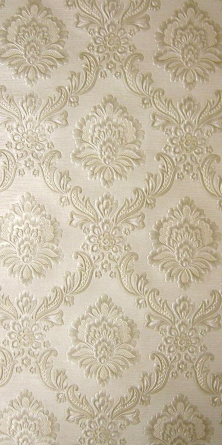 a white wallpaper with an ornate design on it