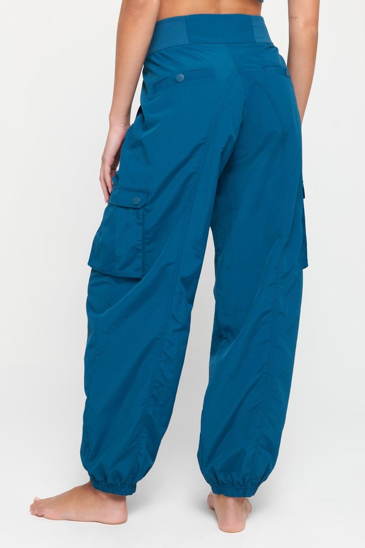 It's giving dancer off the clock. The Taylor Cargo Pant is all things functional, with a lightweight weave and hip side pockets perfect for toting your card, phone, or lip color. Zip and snap waist closure Pleated waist details Hold-anything side pockets Snap closure cargo and back pockets Loose through the leg Jogger fit leg opening | Taylor Cargo Pant in Topaz Rainbow Shop, Yoga Activewear, Spiritual Gangster, Mens Essentials, Cargo Pant, Lip Color, Tank Dress, Sweater Jacket, Lip Colors