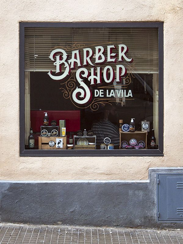 a barber shop sign in the window of a store