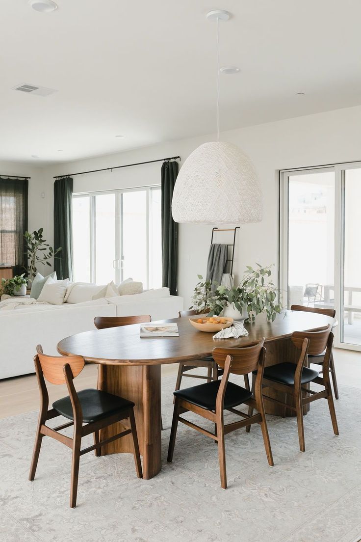 a living room filled with furniture and a large white rug on top of a hard wood floor