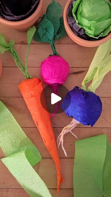 paper flowers and carrots on a wooden table