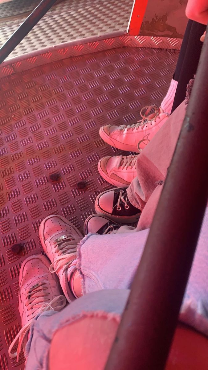 two people sitting on a bench with their feet up