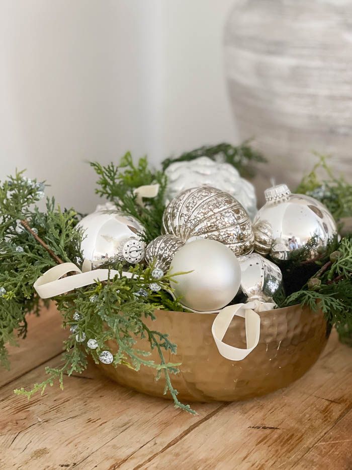 a bowl filled with ornaments on top of a wooden table