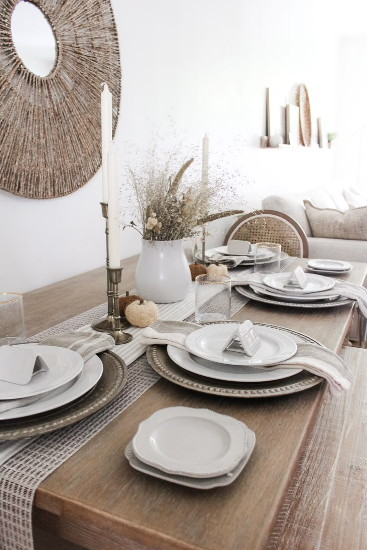 a dining room table set with plates and place settings