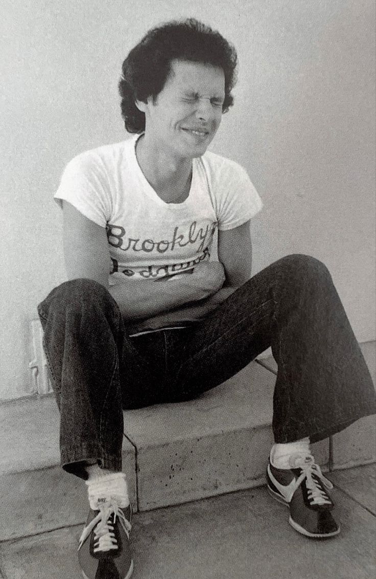 a black and white photo of a woman sitting on steps