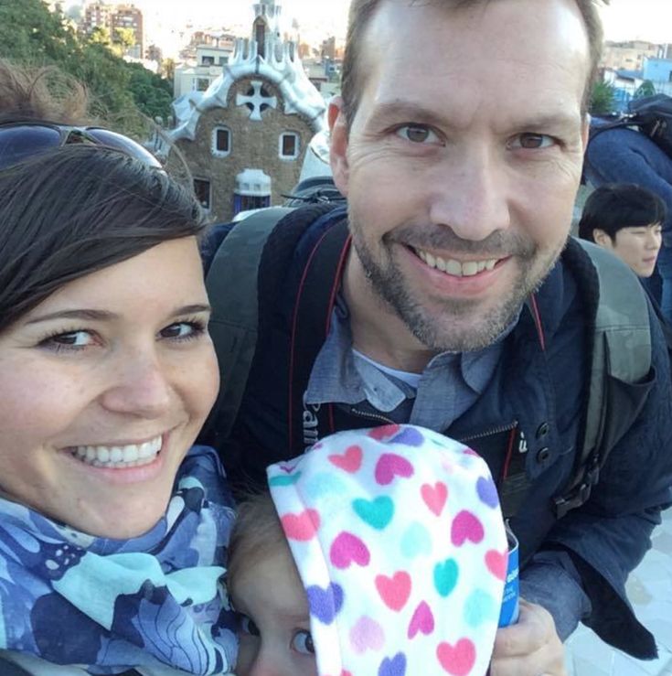 a man and woman smile for the camera while taking a selfie in front of a castle