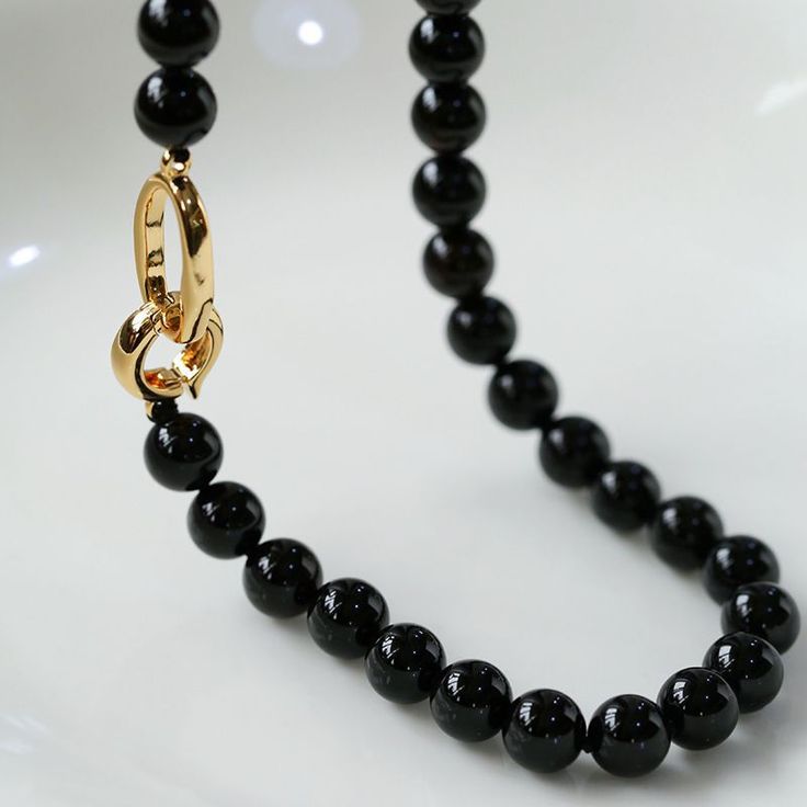 Material: black agate + copper plated 18K goldReplace the previously used white pearls with black onyx beading for a mysterious, gender-neutral appearance. Black is the epitome of timelessness, creating a classic fashion piece. Equipped with a few metal latches, this piece can be worn as a necklace, glasses chain, bracelet, or more. Men can use it as part of their outfit for a fashionable, unisex style. This accessory can be worn alone or stacked to achieve a low-key, stable, and elegant look. Formal Onyx Necklace, Formal Onyx Beaded Necklace, Formal Onyx Round Bead Necklaces, Formal Onyx Beaded Necklaces With Polished Beads, Formal Onyx Necklace With Round Beads, Formal Onyx Beaded Necklace With Round Beads, Formal Onyx Beaded Necklace With Polished Beads, Formal Onyx Jewelry With Polished Beads, Luxury Black Jewelry With Polished Beads