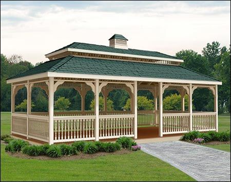 a wooden gazebo sitting on top of a lush green field