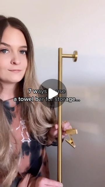 a woman standing next to a gold pole