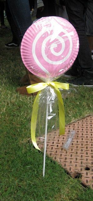 a pink lollipop sitting on top of a white piece of paper in the grass