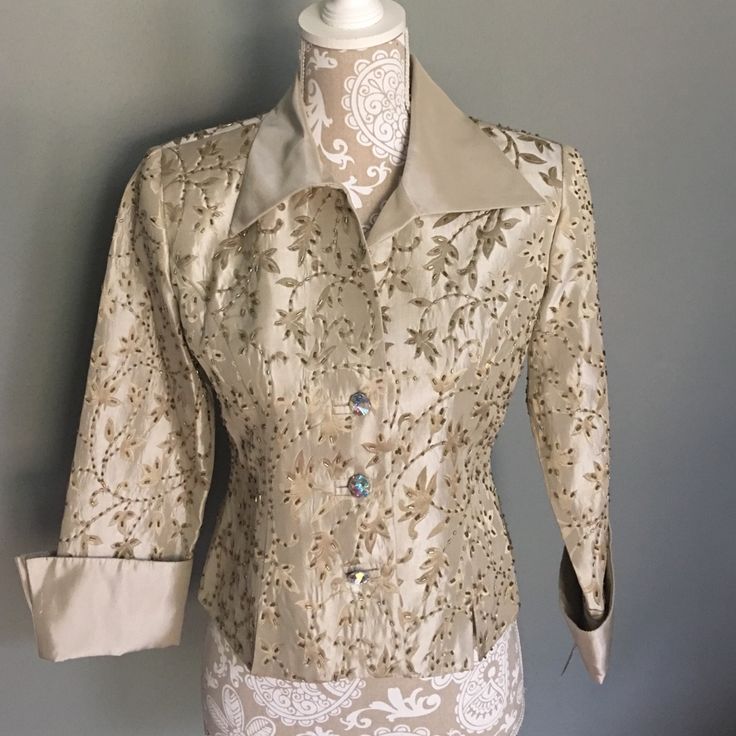 This Button-Up Is Tan-Ish And Stylish. It Has An Embroidered Floral-Like Design That's Beaded For Extra Pizzazz. Price Is Open For Negotiation. Elegant Embellished Beige Tops, Elegant Beige Embellished Tops, Elegant Tops With Gold Buttons, Elegant Tops With Snap Buttons For Formal Occasions, Elegant Formal Tops With Snap Buttons, Elegant Gold Top With Button Closure, Classic Beige Top For Party, Formal Fitted Tops With Pearl Buttons, Elegant Embroidered Beige Tops