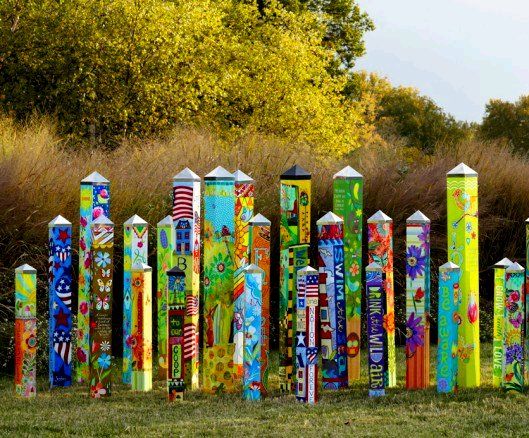 many colorful poles are lined up in the grass