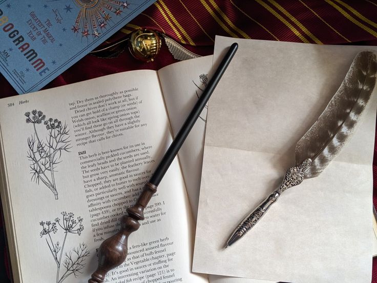 A desktop with the contents of a book open to a description of plants and their uses with a wand laying it across it on one side of the open book. Along with some parchment on and a quill placed on top of the otherside of the opened book. At the top a Gryffindor tie can be seen draped along with a golden snitch with its wings open laying upon it and in the top left corner a pamphlet for the qudditch world cup lies. Hogwarts Student, The Desk, A Student, Homework, Hogwarts, Harry Potter, Desk