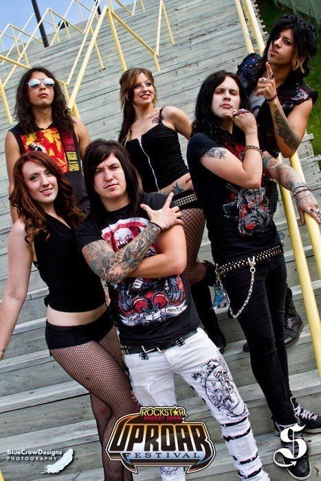 a group of young women standing next to each other in front of stairs with tattoos on their arms