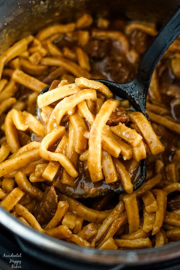 a ladle full of cooked pasta in a pot