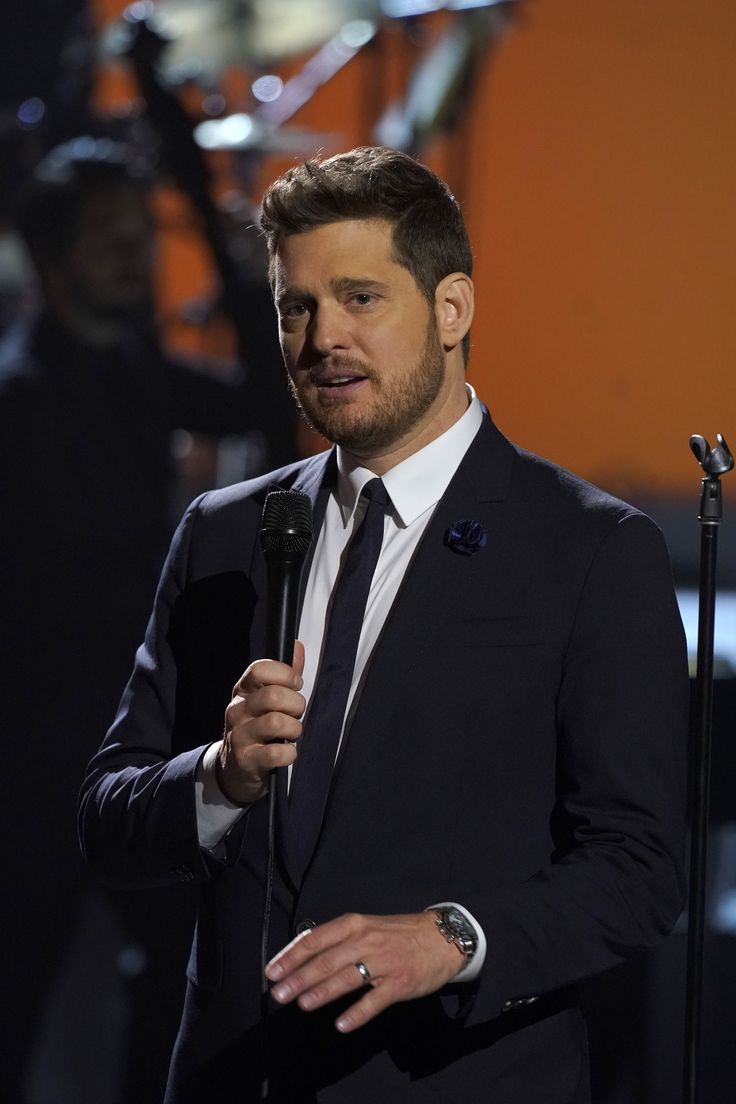 a man in a suit and tie holding a microphone