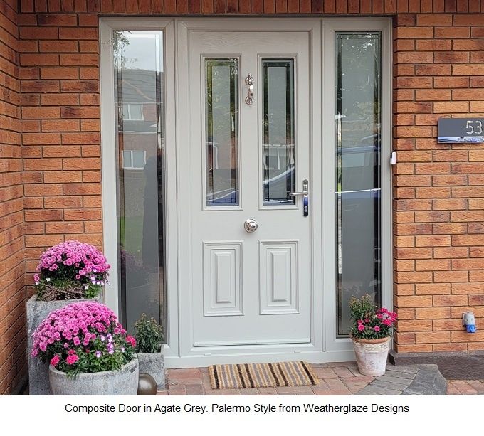 a white front door with two potted flowers on the side and brick wall behind it