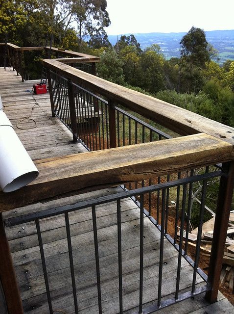 a view from the top of a wooden deck with metal railing and handrails