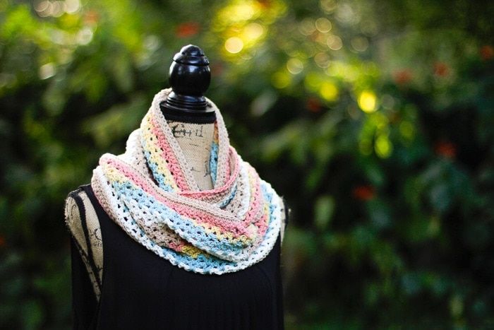 a black mannequin with a multicolored crochet scarf on it