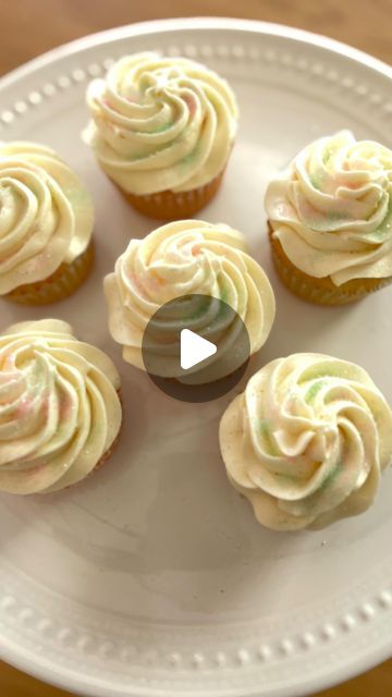 cupcakes with white frosting sitting on a plate